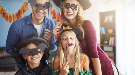 parents and children with halloween props making silly faces